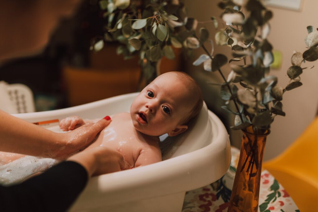 baby showering in bath tab