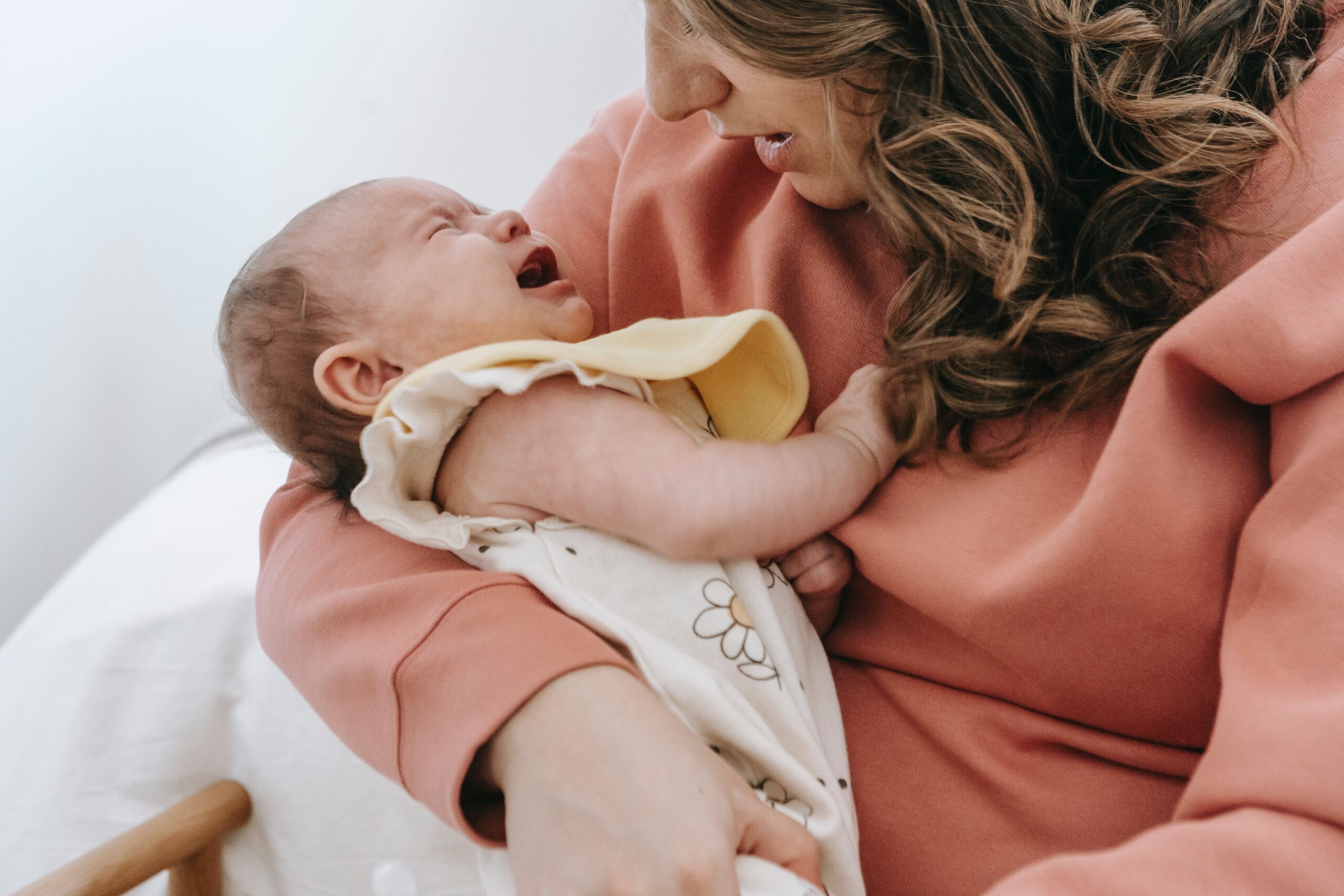 a mother with a crying baby in her hands