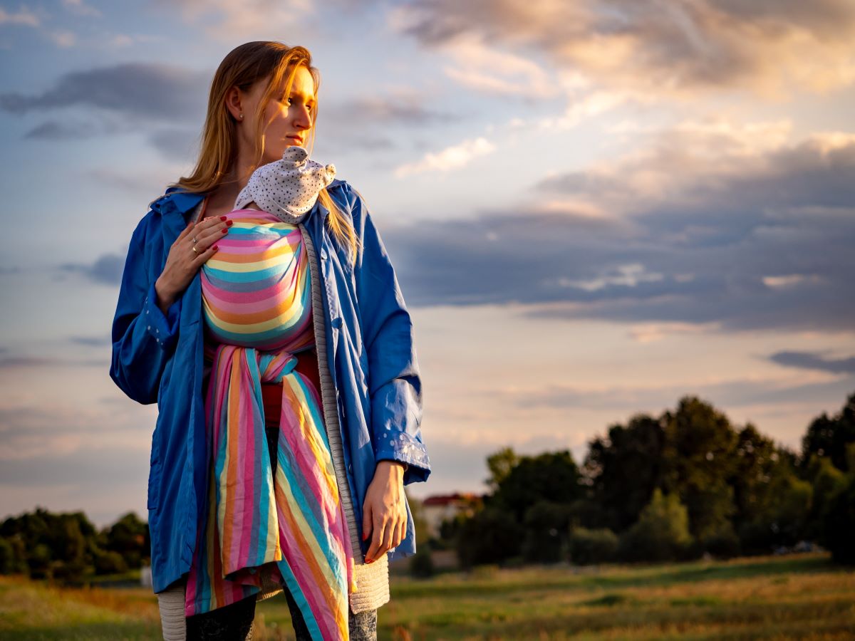 a woman carrying a baby in a wrap