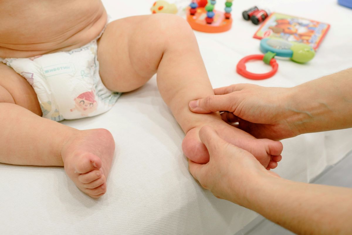 a hand massaging a baby’s foot