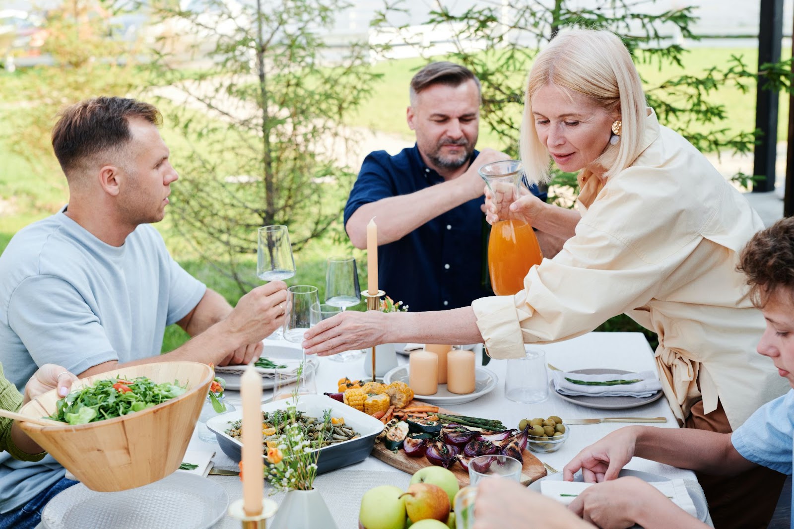 a family having a meal together with a variety of food on the table