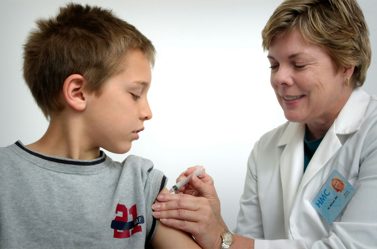 a woman injecting a boy in the arm