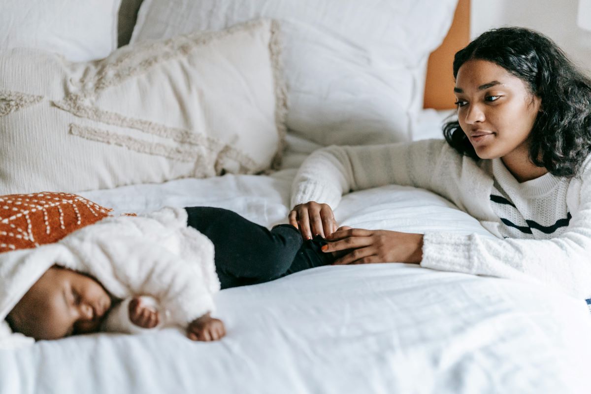 a mother looking at her baby in bed