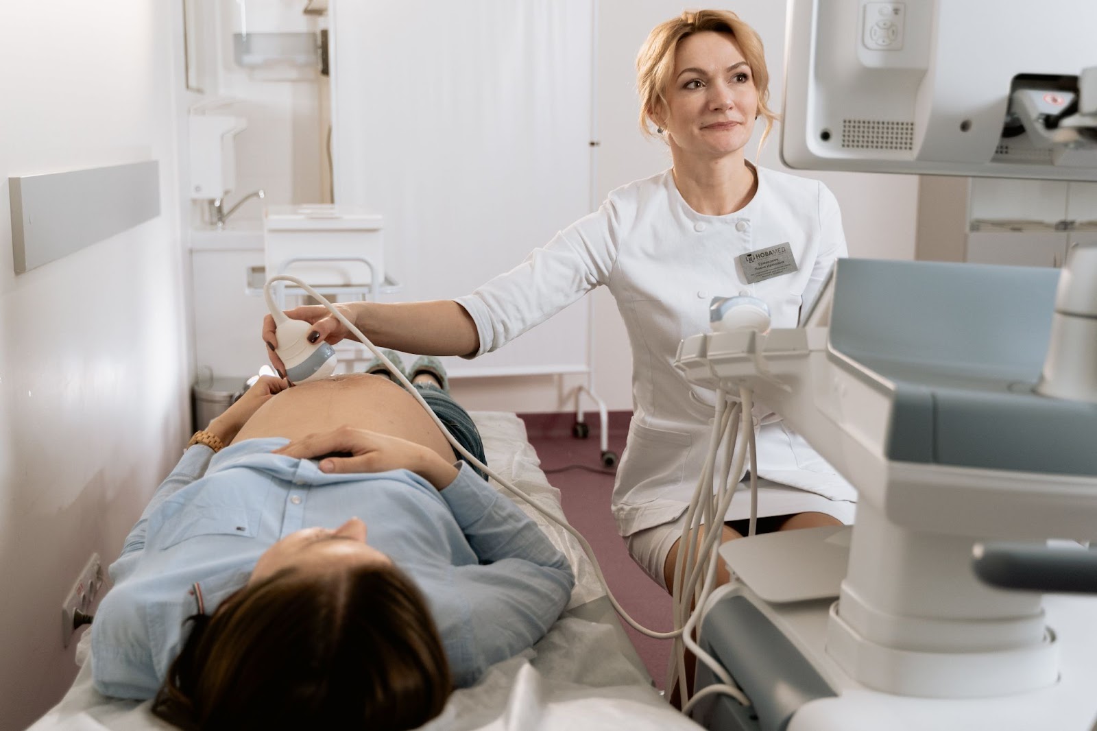 medical practitioner performing stomach ultrasound on woman as a way  to prevent high-risk pregnancy