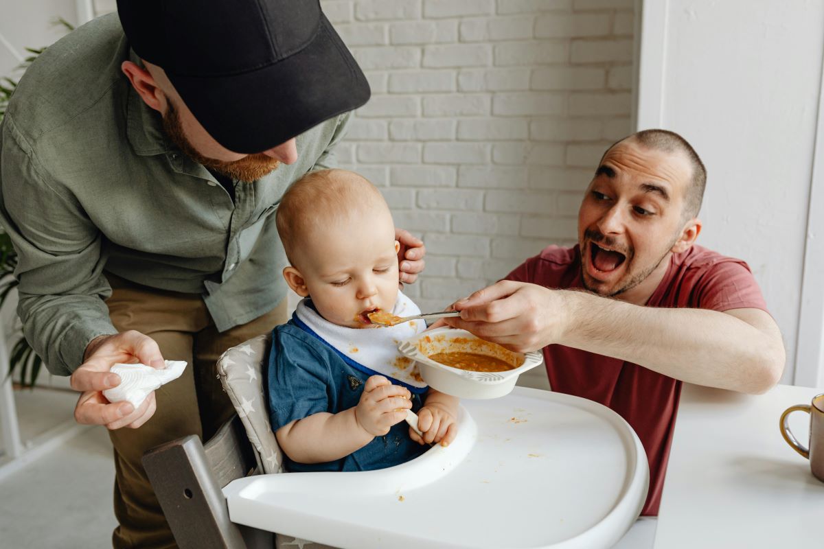 a baby feeding sitting in a high feeding chair