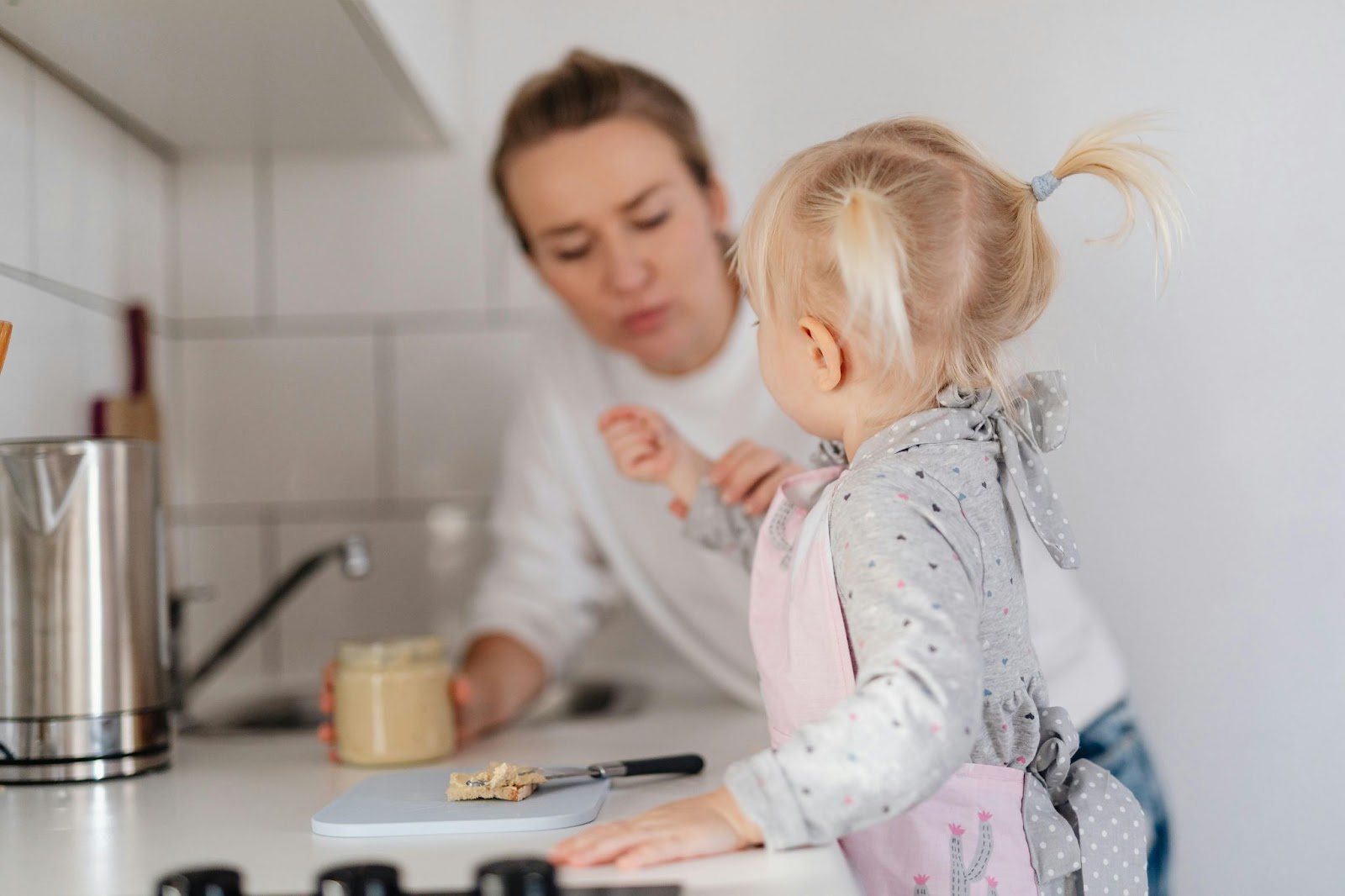 a baby on the counter showing her hand to a woman