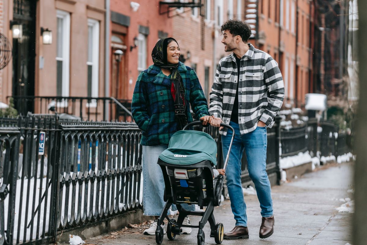 a happy couple pushing a baby stroller