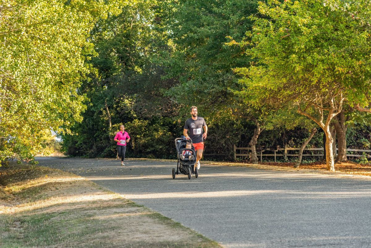 a man jogging pushing a baby on a jogging stroller